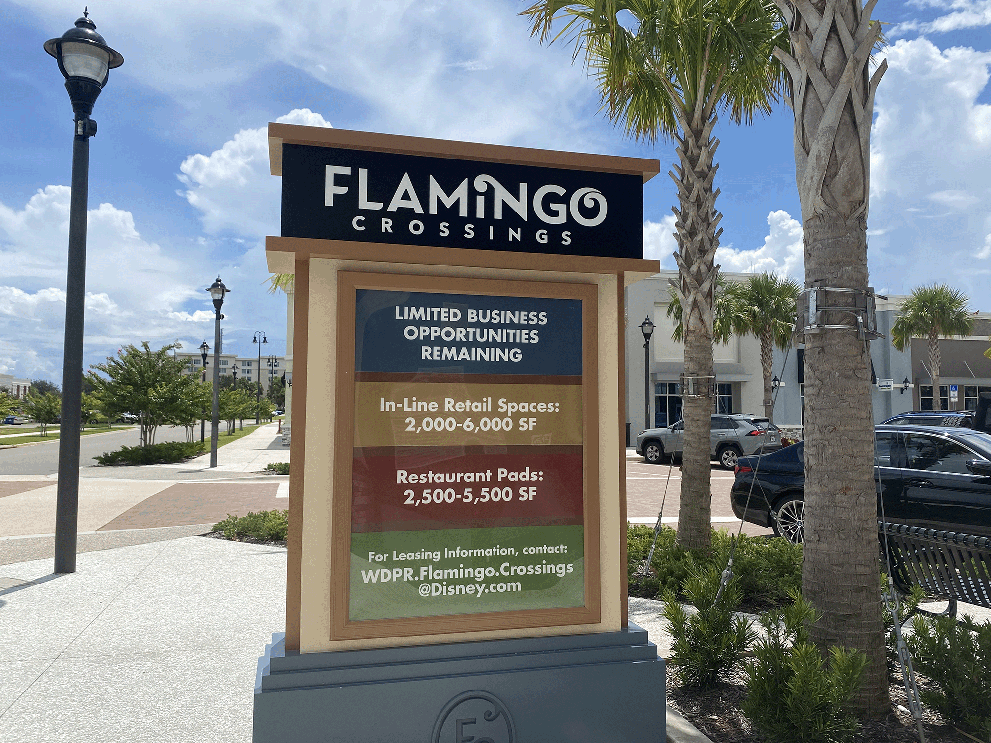flamingo crossings sign outside with palm trees and sidewalk